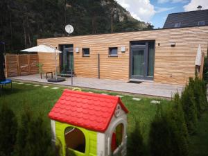 a small house with a red roof in a yard at FREE Ride cabins in Tösens