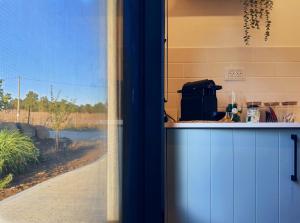 a kitchen with a view of a field through a window at LanGo in Yonatan