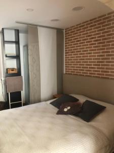 a bedroom with a large bed with a brick wall at Studio Spacieux Cœur Historique in Saint-Rémy-de-Provence