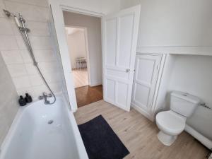 e bagno bianco con servizi igienici e vasca. di Évasion Zen Tropic au Cœur de Châteaudun a Châteaudun Altre 4 foto