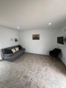 a living room with a couch and a television at RenBeck lets 2 in Urcal