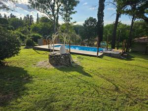 a yard with a swimming pool in the background at El Remanso Estadia Minima 2 Noches in Córdoba