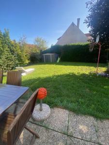 a backyard with a wooden bench and an orange ball at Chambre dans maison près Disneyland Paris - 2 in Brie-Comte-Robert