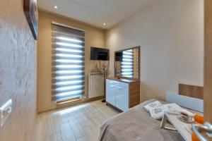 a bedroom with a bed and a tv and a window at Apartman Mihajlo Kalman in Zlatibor +54 photos