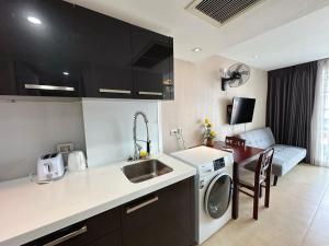 a kitchen with a sink and a washing machine at Centara Avenue Residence By Daisy Pattaya 1 in Pattaya Central