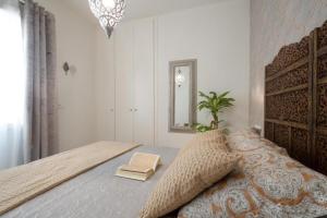 Moriscos Luxury Suite في غرناطة: غرفة نوم بسرير مع كتاب ومرآة +14 صورة