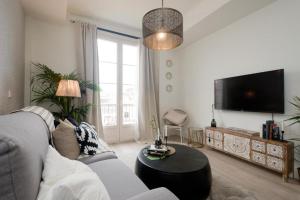 Moriscos Luxury Suite في غرناطة: غرفة معيشة بها أريكة وجهاز تلفزيون