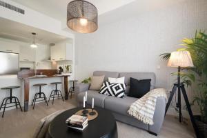 Moriscos Luxury Suite في غرناطة: غرفة معيشة مع أريكة رمادية وطاولة