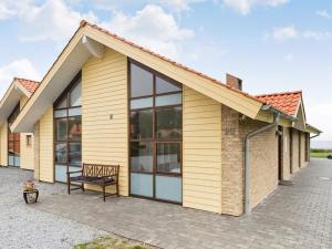 a house with yellow siding and a bench at 6 person holiday home in Egernsund in Egernsund