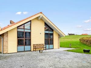 a yellow house with a bench in front of it at 6 person holiday home in Egernsund in Egernsund