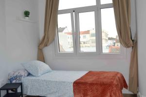 a bedroom with a bed and a window at Yellowstone Ático luminoso y acogedor in Ferrol