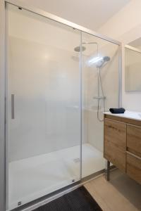 a glass shower in a bathroom with a sink at Massao appart in Montargis +11 photos