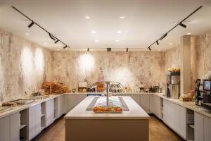een grote keuken met een aanrecht met fruit erop bij Monet Garden Hotel Amsterdam in Amsterdam