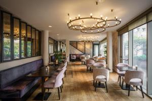 un ristorante con tavoli, sedie e un lampadario di Monet Garden Hotel Amsterdam ad Amsterdam