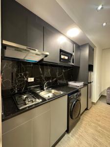 a kitchen with a sink and a stove top oven at central apartment for rent 17 in Amman