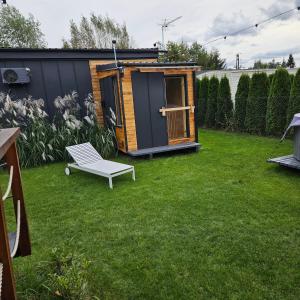 a small shed with a bench in a yard at IDEA Wypoczynek Domek Jezioro Białe in Okuninka