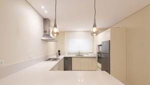 a kitchen with white walls and a white counter top at Sheikh Zayed New Giza Near GEM & MOA in Abū Rawwāsh