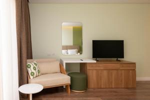 a living room with a tv and a chair at Sheikh Zayed New Giza Near GEM & MOA in Abū Rawwāsh