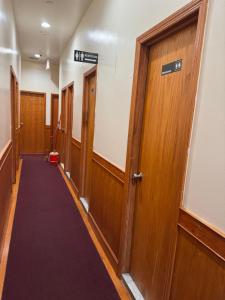 a hallway with wooden doors and a purple carpet at U.S. Pacific Hotel in New York