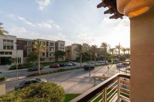 a view from a balcony of a street with parked cars at Sheikh Zayed New Giza Near GEM & MOA in Abū Rawwāsh