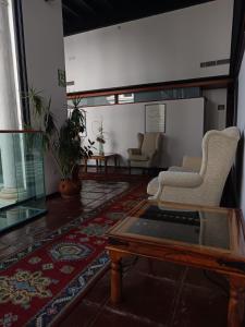 a living room with two chairs and a coffee table at Hotel Escuela Convento Sto Domingo in Archidona