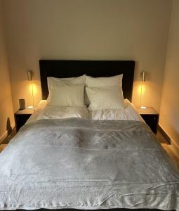 a bed with white sheets and pillows in a bedroom at Aarhus - cozy house, 10 min from city center in Aarhus