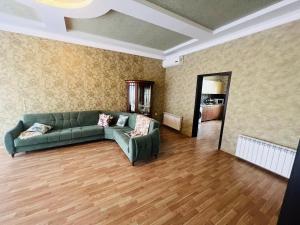 a living room with a green couch and wooden floors at Villa in Mardakan,COP29 in Baku +4 photos