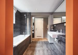 a large bathroom with two sinks and a tub and a tubermott at Villa Sablon in Brussels