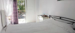 Un dormitorio con una cama blanca y una ventana. en FBM Anagenessis - Ευ Ζην 2, en Édessa 11 fotos más