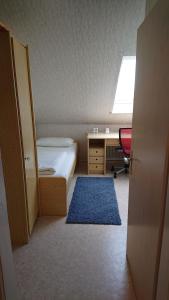 a bedroom with a bed and a desk and a window at Ferienwohnung in Ländliche Gegend die zum Verweilen einlädt in Wachenroth