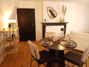 a living room with a table and a couch at Le Charmant in Sévérac d' Aveyron +11 photos
