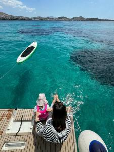 una mujer y un niño en un barco en el agua en Luxury Sailing Cruises in Athens with Traditional Greek Cuisine and Drinks, en Atenas