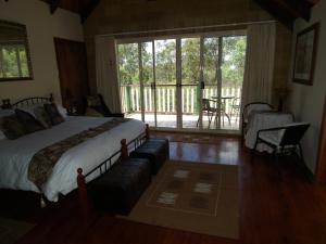 ein Schlafzimmer mit großem Bett und Balkon in der Unterkunft Back to the Bush in Aramara