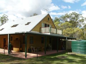 a house with a porch and a deck at Back to the Bush in Aramara