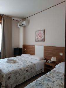 A bed or beds in a room at Hotel Mucciolini
