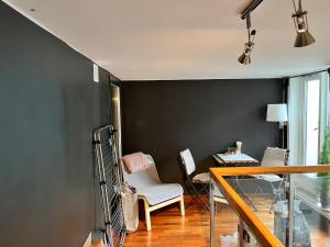 a room with a black wall and a chair and a table at Large Room with Balcony -two storey condo- nearby Scandic Business Center bus stop in Stavanger