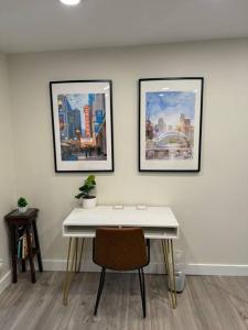 una scrivania bianca con tre foto su un muro di Cozy Corner Charming 1BR with WiFi a Skokie Altre 3 foto
