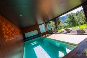 a house with a swimming pool and a deck at La Fuste du Lac in Chambon-sur-Lac