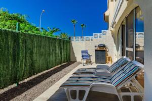 a row of chaise lounge chairs on a patio at Lovely apartment in Callao Salvaje in Callao Salvaje