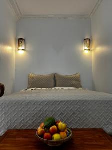 a bowl of fruit on a table in front of a bed at Casa Indigo in Rabat +38 photos