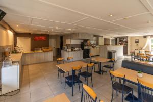 a restaurant with tables and chairs and a kitchen at Sleep & Go Brugge in Bruges