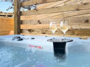 two glasses of wine sitting next to a swimming pool at GGs Holiday Let in Poulton le Fylde