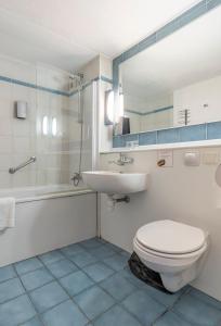 a bathroom with a toilet and a sink and a shower at Sleep & Go Brugge in Bruges +42 photos