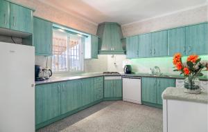 a kitchen with green cabinets and a vase of flowers at 2 Bedroom Lovely Home In Carratraca in Carratraca