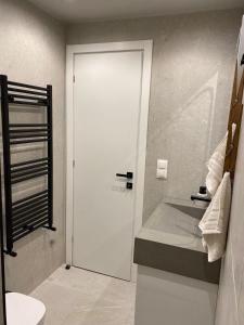 a bathroom with a white door and a sink at SimOtel Downtown Suite in Thessaloniki +33 photos
