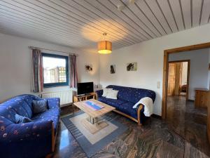 a living room with a blue couch and a table at Ferienwohnung Isi-Blick in Osterby