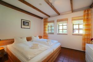 une chambre avec un grand lit blanc dans une pièce dans l'établissement Ferienhaus Gandur, à Osterby