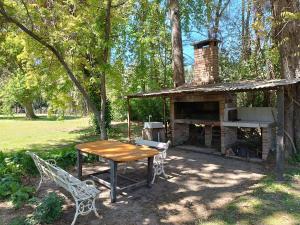 una mesa y sillas frente a un horno de ladrillo en Quinta isleña Las Marías - Pileta - Domingos Check out 17 hs, en Tigre