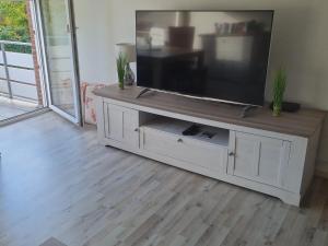 a large flat screen tv on a white entertainment center at Ferienwohnung Eichhörnchen in Krefeld