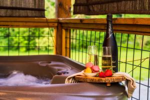 einen Whirlpool mit einer Flasche Wein und Obst in der Unterkunft Romantic Cabin - The Woodland Nook in Sevierville